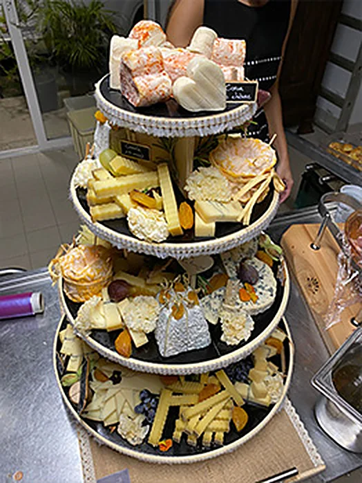 Présentoir à étages garni de fromages pour une réception